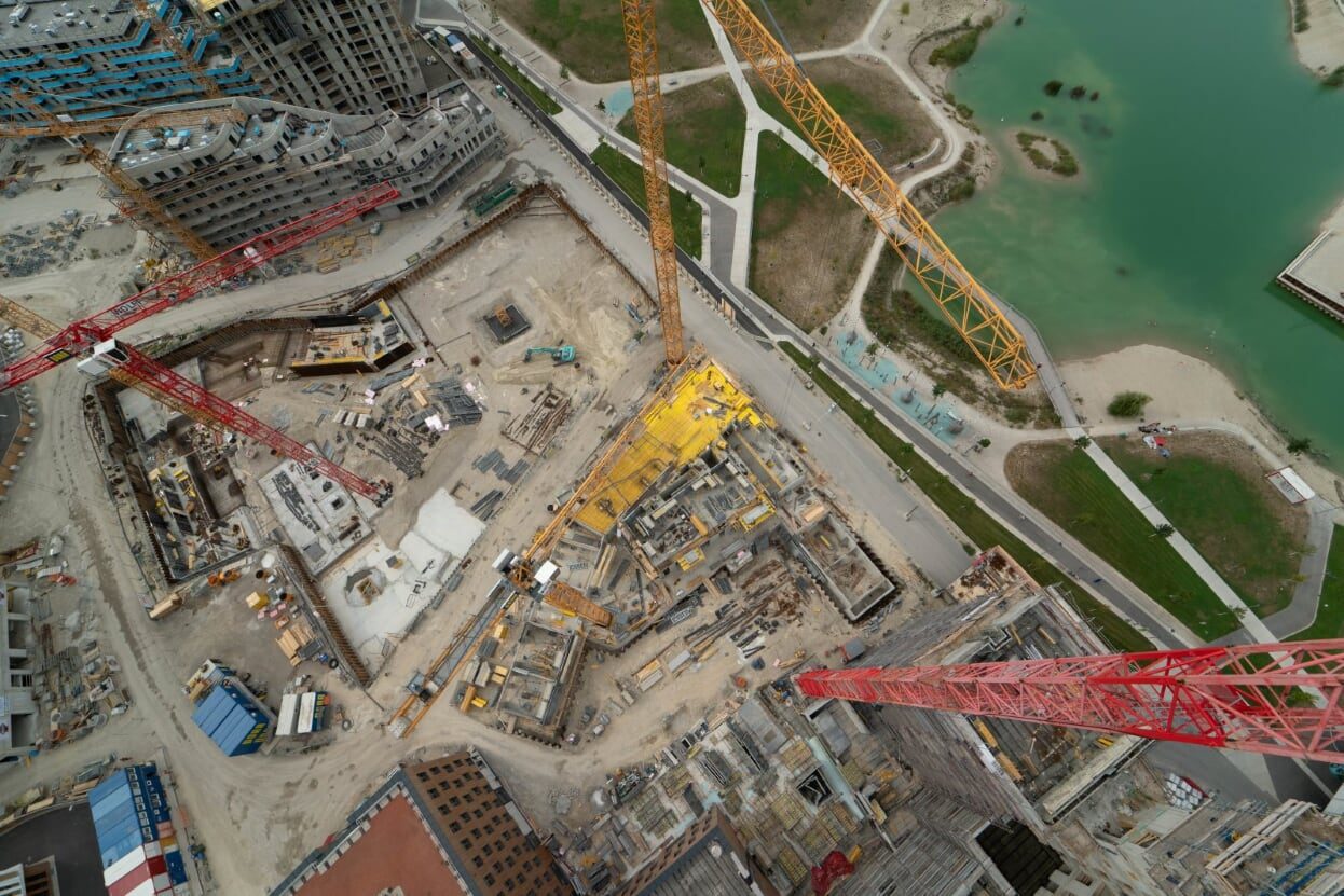 Luftaufnahme einer Großbaustelle mit mehreren Turmdrehkränen
